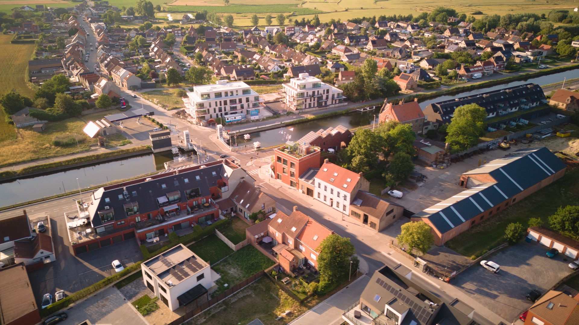 Aerial view of Oudenburg, Belgium, showcasing residential buildings and green landscapes.